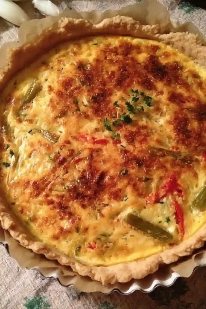 Quiche lorraine revisitée dorée au four avec dinde fumée, légumes et herbes fraîches