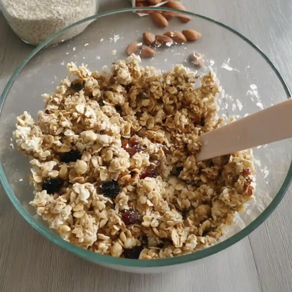 Mélange de flocons et fruits secs dans saladier pour granola sans sucre ajouté