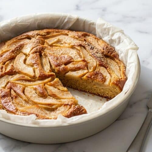 Gâteaux aux poires et amandes dorés, parfumés par la poudre d'amande torréfiée, sur une assiette de service.