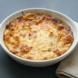Pudding salé au jambon gratiné et doré dans un petit plat à gratin.