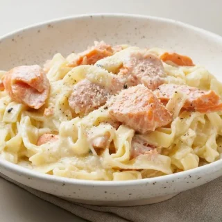 Tagliatelles onctueuses aux dés de saumon frais poché dans une sauce crémeuse pour la recette des pates au saumon.