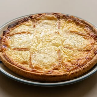 Tarte au maroilles dorée et fondante tout juste sortie du four avec sa pâte croustillante