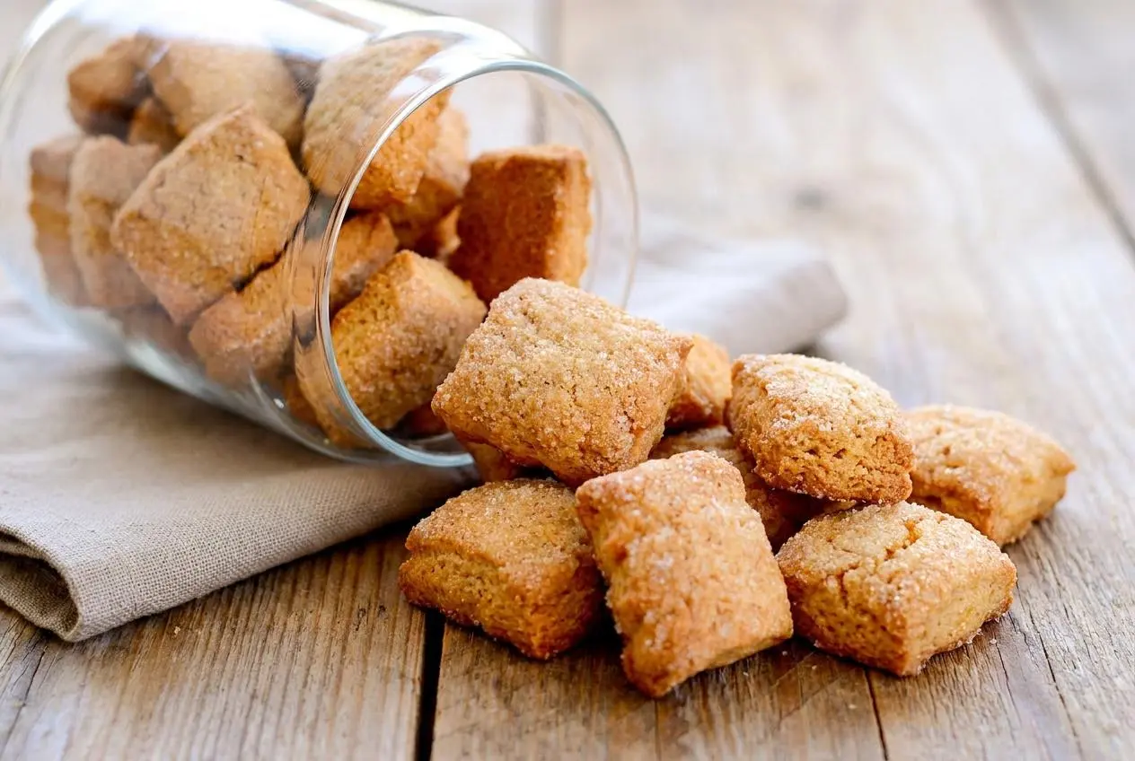 Recette des Canistrelli croustillants et dorés, parsemés de sucre cristal sur une assiette.