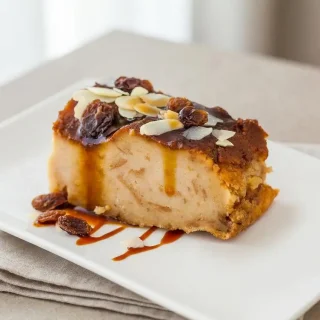 Recette pudding au pain dorée au four garnie de raisins moelleux dans un plat de cuisson.